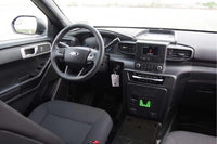 Car interior with steering wheel, Feniex 4200 Mini Controller , and center console.