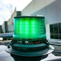 Green Feniex AM600 Beacon on a vehicle with 'Fenix' branding in an urban setting