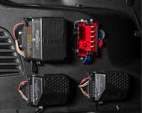 Automotive Feniex Storm 200W Siren on a black car mat with 'Feniex' branding.