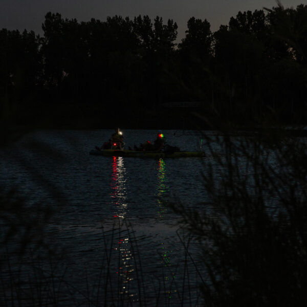 Boat with lights on a dark body of water at night