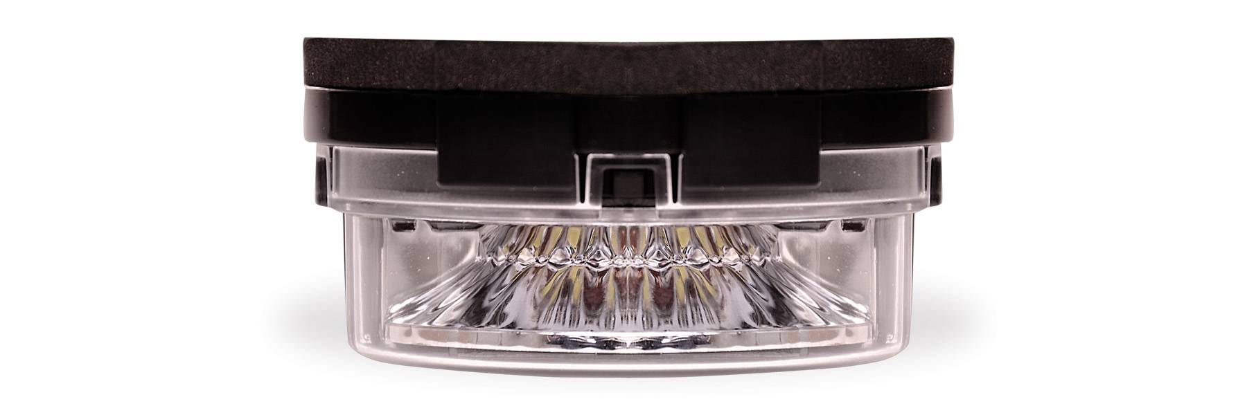 Car headlight with clear lens and black casing on a white background