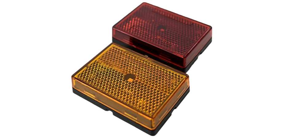 Two TecNiq S25 : Retro Reflector Side Marker Light, one red and one orange, on a white background.